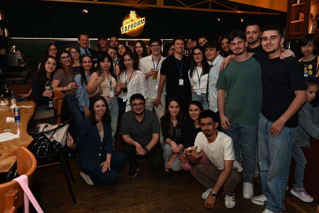 Large group photo of the DuaCrypto community gathered at The Taproom in Tirana